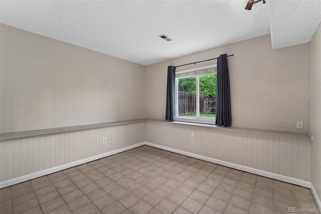11532 Newland St, Westminster, CO 80020 - empty room with a textured ceiling, wainscoting, and wood walls