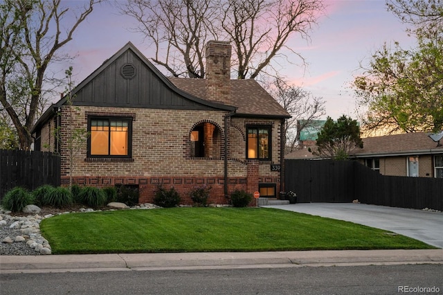 english style home featuring brick siding, a chimney, and board and batten siding