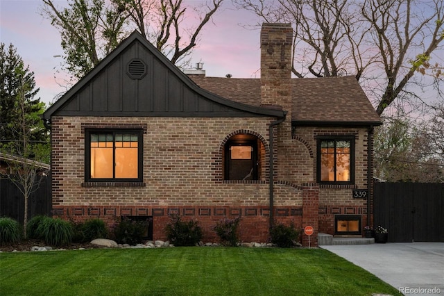 view of front of property featuring brick siding, board and batten siding, a chimney, and a shingled roof