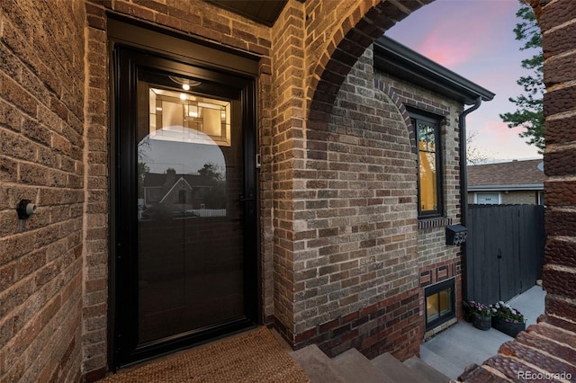 exterior entry at dusk with brick siding