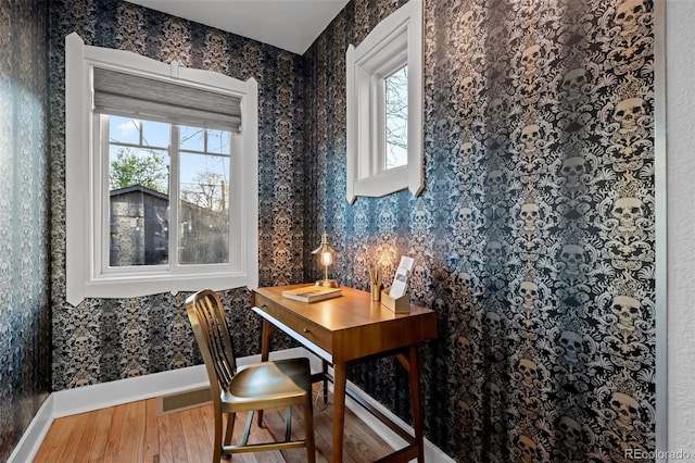 home office featuring wood finished floors, baseboards, and wallpapered walls