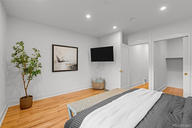 bedroom featuring wood finished floors, baseboards, and recessed lighting