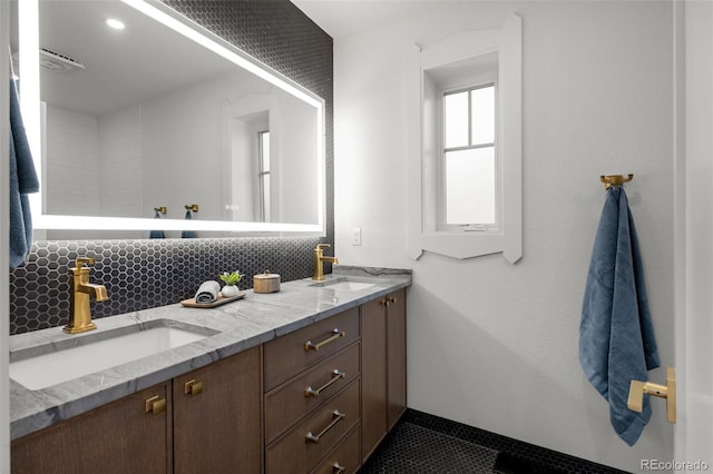 full bathroom with double vanity, baseboards, and tasteful backsplash