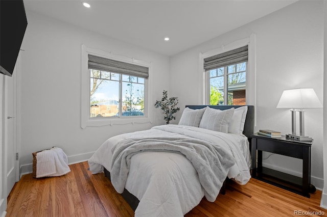 bedroom with wood finished floors, baseboards, and recessed lighting