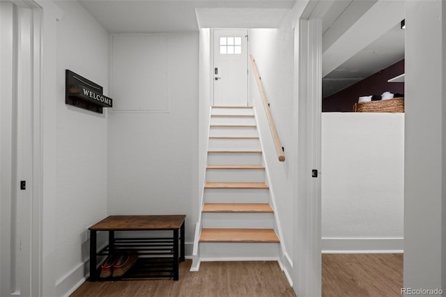 stairway featuring wood finished floors and baseboards