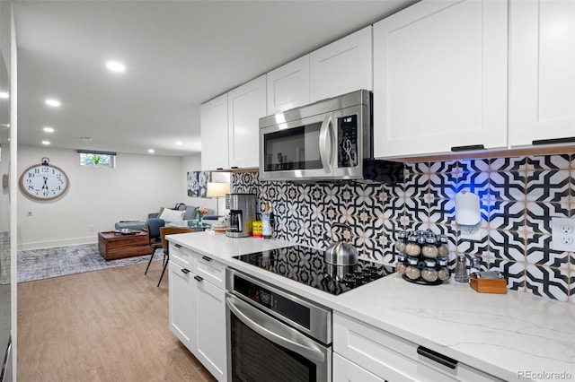kitchen with appliances with stainless steel finishes, light wood-style flooring, decorative backsplash, recessed lighting, and light stone counters