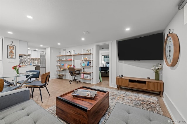 living room featuring light wood-type flooring, recessed lighting, and baseboards