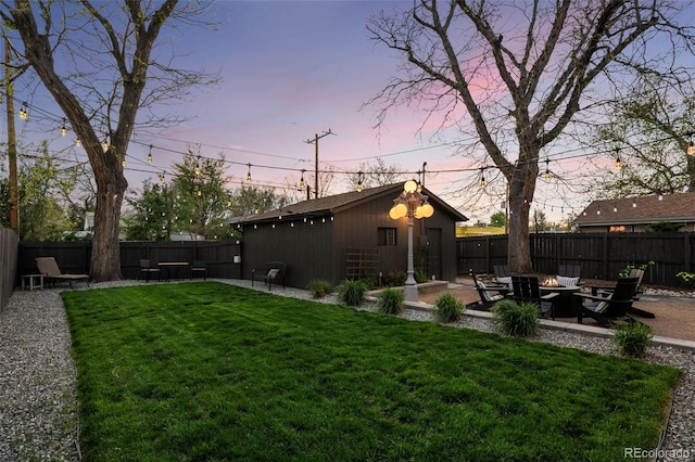 yard at dusk with an outdoor fire pit and a patio