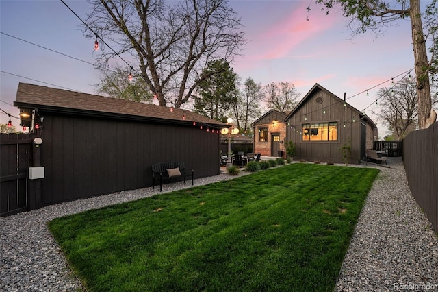 back of property at dusk featuring a patio
