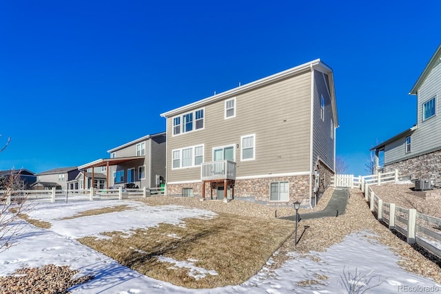 snow covered house featuring cooling unit