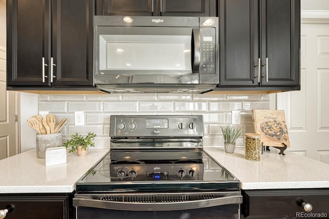 kitchen with backsplash, light stone countertops, black appliances, and dark brown cabinets