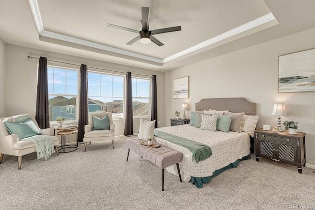 bedroom featuring ceiling fan, light carpet, and a tray ceiling