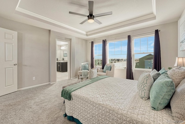 bedroom featuring ceiling fan, connected bathroom, a raised ceiling, and carpet