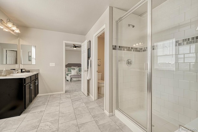 bathroom featuring toilet, tile patterned floors, an enclosed shower, ceiling fan, and vanity