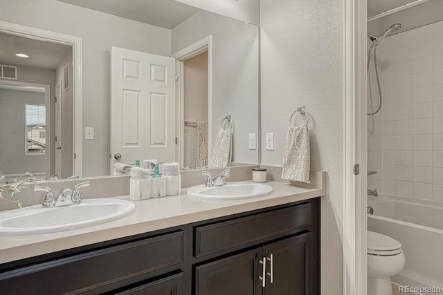 full bathroom with toilet, vanity, and tiled shower / bath