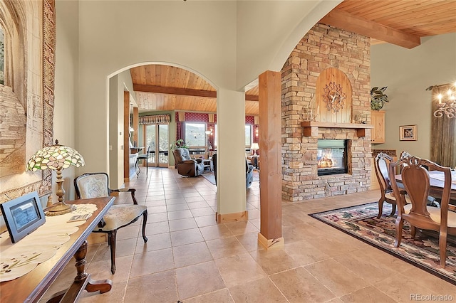 2433 Dogie Spur, Golden, CO 80403 - interior space with a fireplace, wood ceiling with exposed beams, arched walkways, baseboards, and high vaulted ceiling