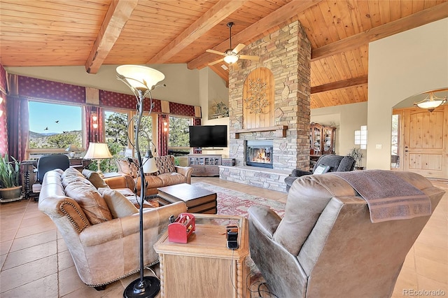 2433 Dogie Spur, Golden, CO 80403 - living room featuring healthy amount of natural light, a stone fireplace, wooden ceiling with exposed beams, ceiling fan, and tile patterned floors