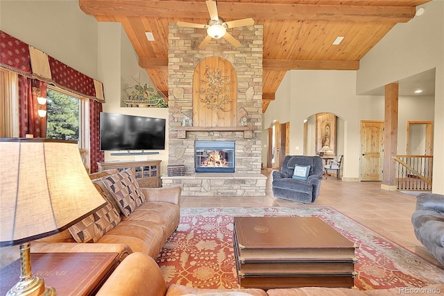 2433 Dogie Spur, Golden, CO 80403 - tiled living area featuring high vaulted ceiling, ceiling fan, arched walkways, wood ceiling with exposed beams, and a fireplace