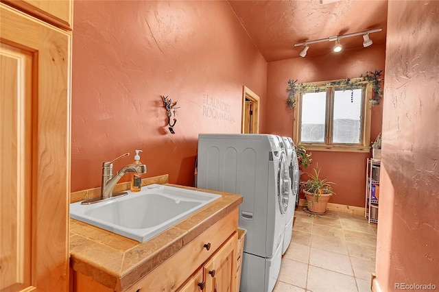 2433 Dogie Spur, Golden, CO 80403 - washroom with washer and clothes dryer, cabinet space, track lighting, light tile patterned floors, and baseboards