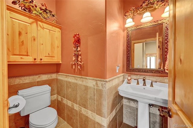 2433 Dogie Spur, Golden, CO 80403 - bathroom with tile walls, toilet, a wainscoted wall, and tile patterned flooring