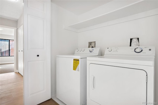 laundry room with independent washer and dryer and wood-type flooring