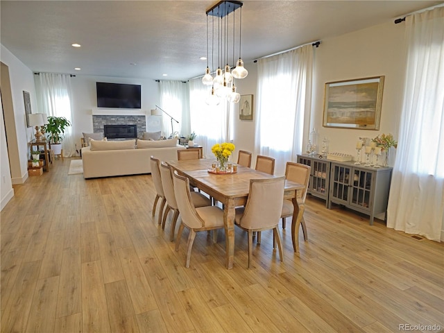 dining room featuring a fireplace and light wood-type flooring