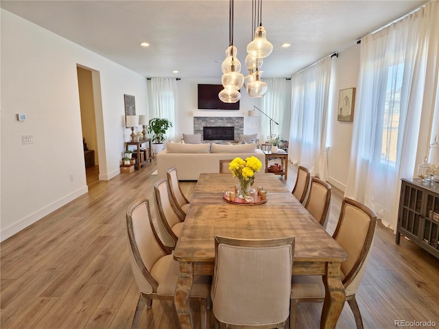 dining room with a fireplace and light wood-type flooring