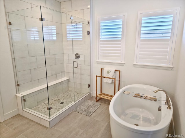 bathroom featuring a healthy amount of sunlight and separate shower and tub