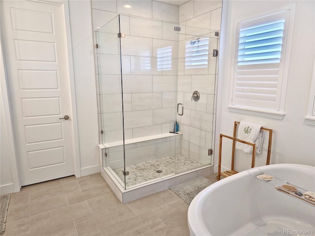 bathroom featuring tile patterned flooring and shower with separate bathtub