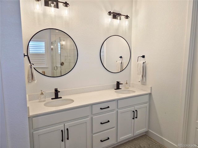 bathroom featuring a shower with door and vanity