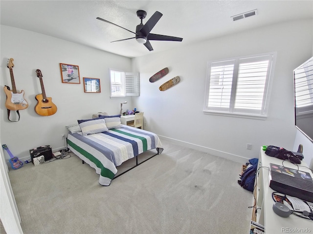 bedroom featuring ceiling fan, light colored carpet, and multiple windows