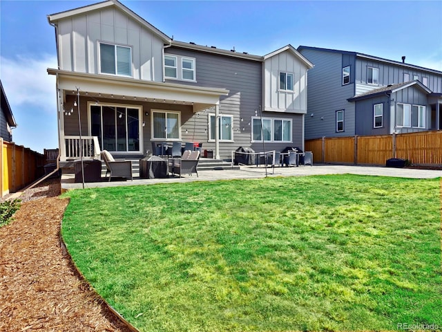 back of house with outdoor lounge area, a patio area, and a lawn