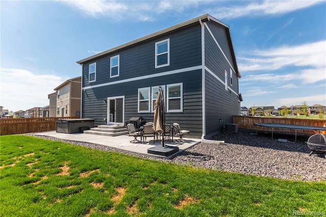 920 William Way, Brighton, CO 80603 - rear view of property featuring a trampoline, a hot tub, and a patio