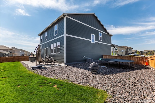 920 William Way, Brighton, CO 80603 - back of house with a trampoline, a patio area, and a residential view