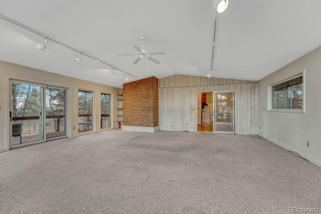 unfurnished living room with carpet floors, lofted ceiling, track lighting, and a ceiling fan