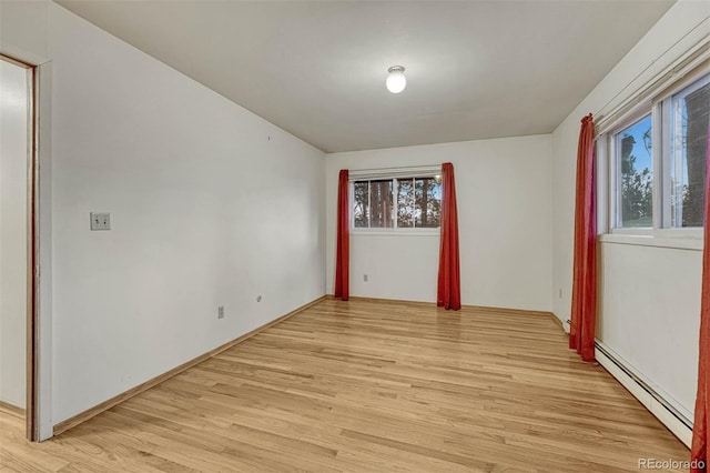 empty room with a baseboard heating unit and light wood-style flooring