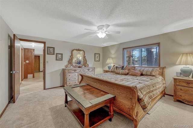 bedroom with light carpet, ceiling fan, a textured ceiling, and baseboards