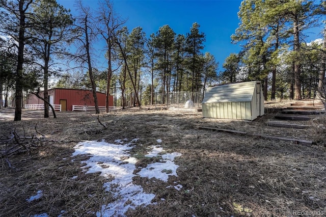 view of yard featuring an outbuilding, an outdoor structure, and fence