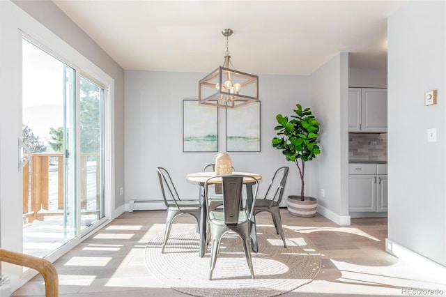 dining area with a notable chandelier and light hardwood / wood-style floors