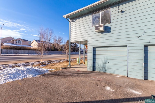 view of snowy exterior featuring a garage