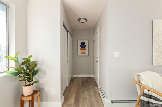 hall with baseboard heating and hardwood / wood-style floors