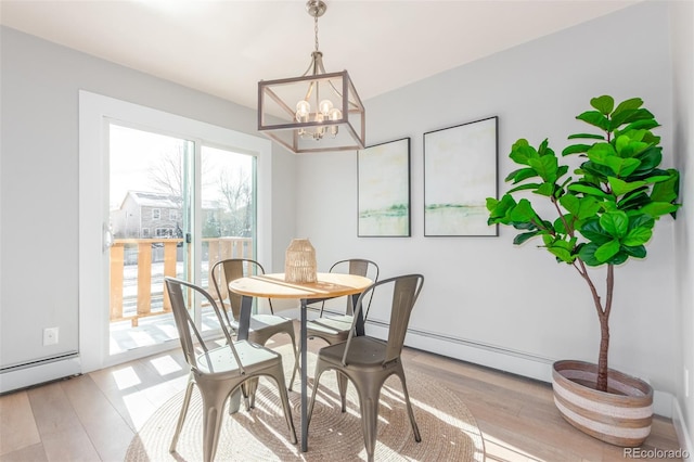 dining room with light hardwood / wood-style floors, a baseboard radiator, and a chandelier