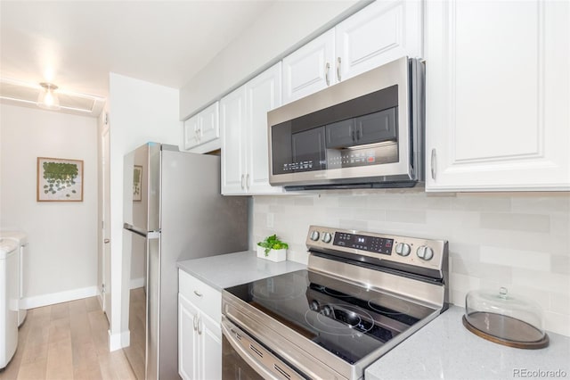 kitchen featuring light hardwood / wood-style floors, washer / clothes dryer, stainless steel appliances, white cabinets, and tasteful backsplash