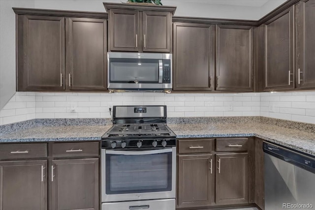 7218 Animas Ave, Frederick, CO 80530 - kitchen with appliances with stainless steel finishes, dark brown cabinets, decorative backsplash, and light stone counters
