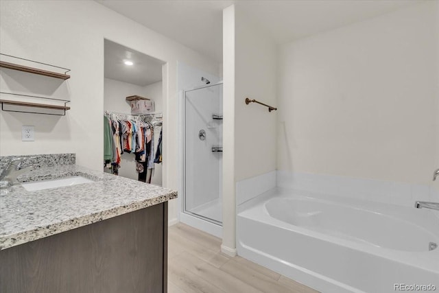 7218 Animas Ave, Frederick, CO 80530 - full bathroom with a bath, a stall shower, vanity, and wood finished floors