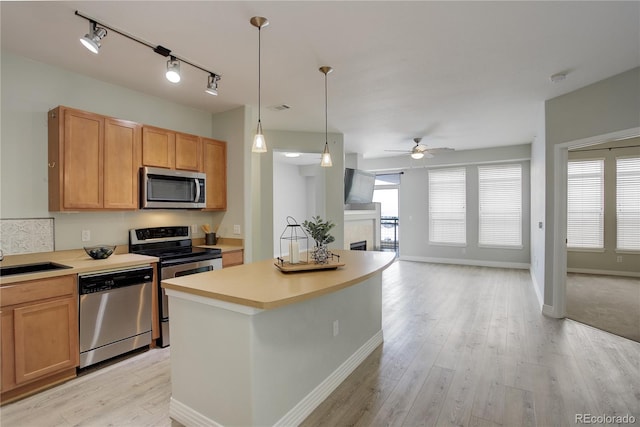 kitchen featuring plenty of natural light, appliances with stainless steel finishes, open floor plan, and a sink