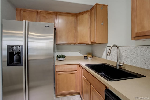 kitchen with dishwasher, stainless steel refrigerator with ice dispenser, a sink, and light countertops