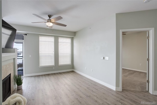 unfurnished living room with a fireplace, wood finished floors, and baseboards