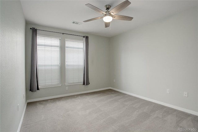 unfurnished room featuring a ceiling fan, light colored carpet, visible vents, and baseboards