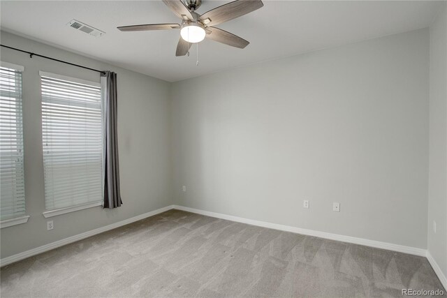 empty room with light carpet, baseboards, visible vents, and a ceiling fan